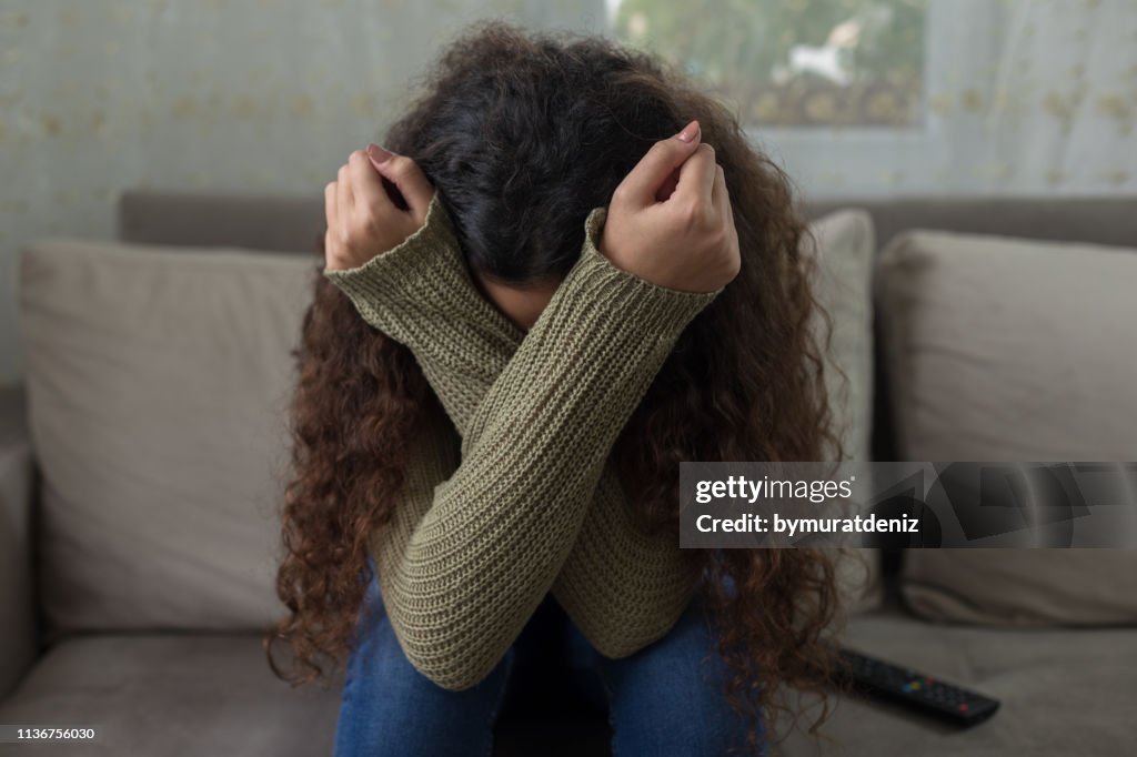 Unhappy girl on sofa