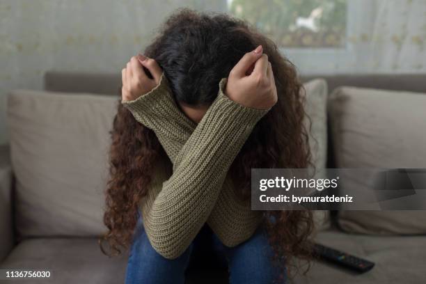 unhappy girl on sofa - aterrorizado imagens e fotografias de stock