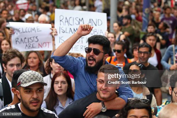 Protesters hold placards aloft as they march during the Stand Against Racism and Islamophobia: Fraser Anning Resign! rally on March 19, 2019 in...