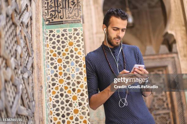 homme arabe écoutant la musique sur son téléphone - musique marocaine photos et images de collection
