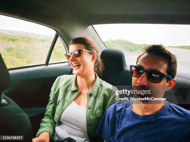 young couple laughing in car during road trip - taken on mobile device stock pictures, royalty-free photos & images
