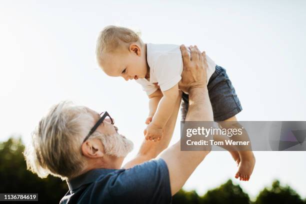 grandpa holding grandchild in the air - baby grandpa imagens e fotografias de stock