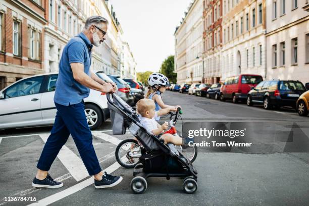 grandpa crossing the street with grandchildren. - car safety kids road stock pictures, royalty-free photos & images