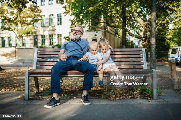 grandpa sitting on bench with grandchildren - berlin people ��ストックフォトと画像