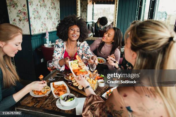 sharing food - placer fotografías e imágenes de stock