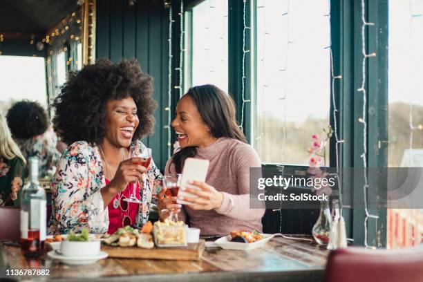 laughing at a joke - black woman laughing stock pictures, royalty-free photos & images