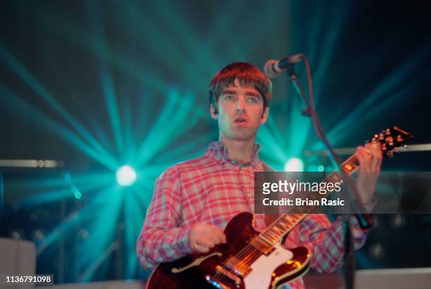 English musician Noel Gallagher, guitarist with Oasis, performs live on stage with the band at Earls Court Exhibition Centre in London in November...