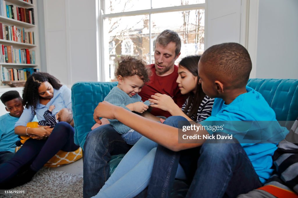 Multi ethnic family relaxing in living room