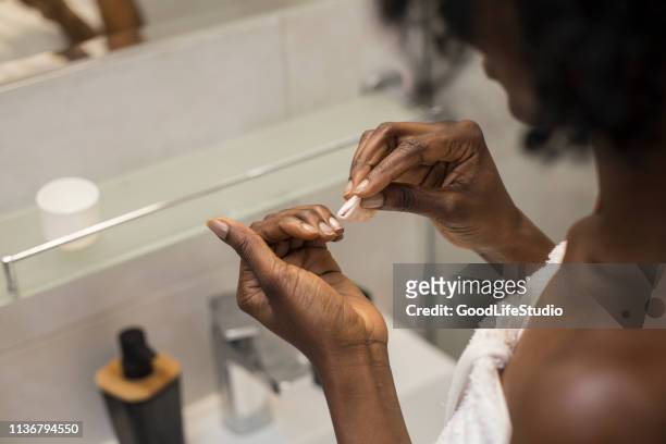 woman removing her nail polish - nail polish stock pictures, royalty-free photos & images
