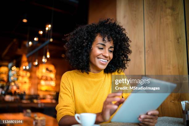 smiling woman using digital tablet. - american influencer stock pictures, royalty-free photos & images