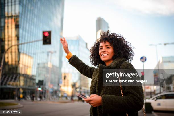 taxi please. - mulher chamando imagens e fotografias de stock