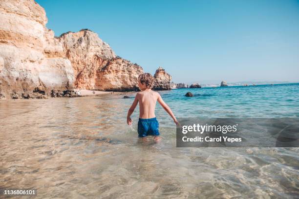 little blonde boy having at beach - children por stock-fotos und bilder