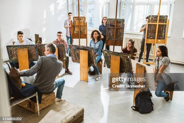 grande grupo de estudantes que têm uma classe de arte com seu professor em um estúdio. - desenhar atividade - fotografias e filmes do acervo