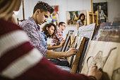 Group of art students drawing paintings at art studio.