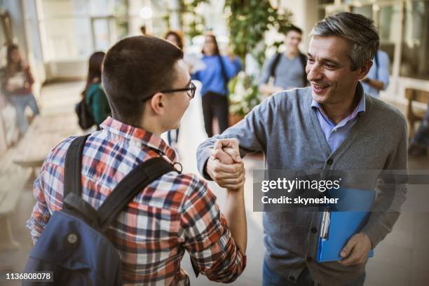 happy teacher and high school student greeting in a hallway. - lecturer students stock pictures, royalty-free photos & images