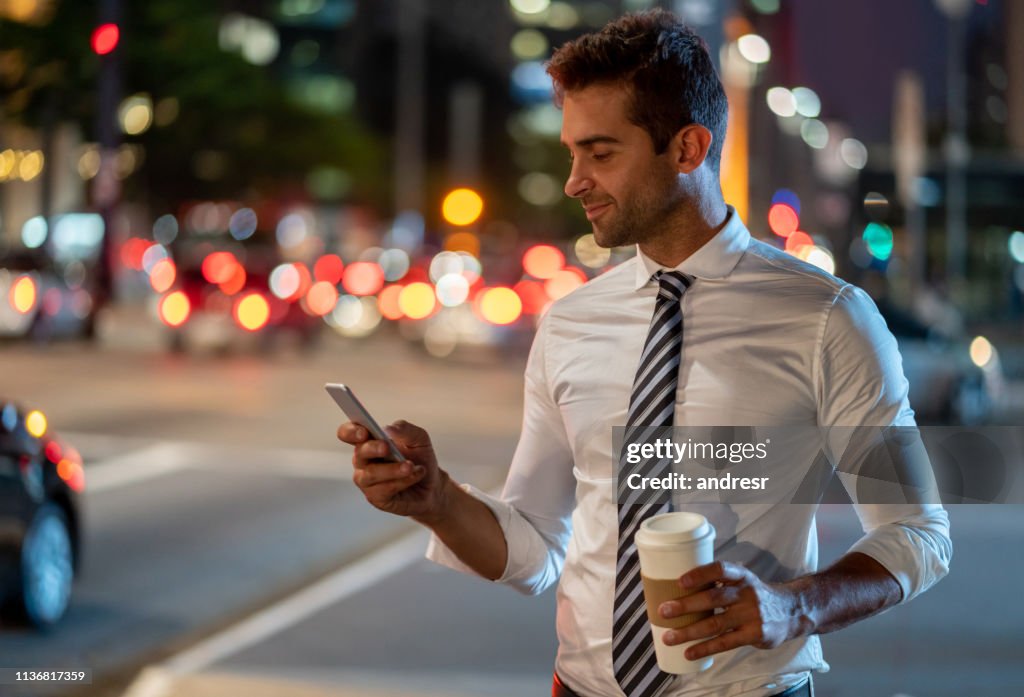Business man on the street requesting a taxi on his cell phone