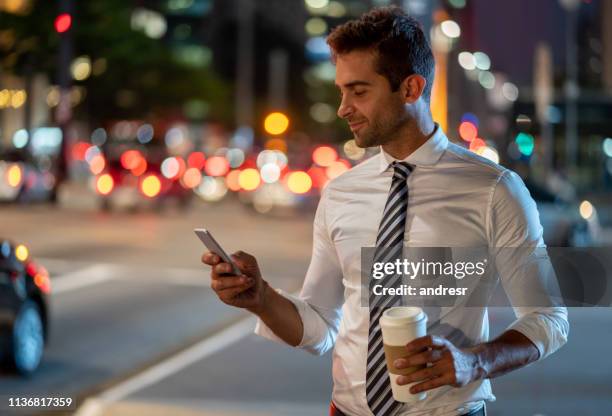 business man on the street requesting a taxi on his cell phone - crowdsourcing stock pictures, royalty-free photos & images