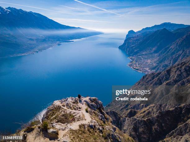 sucesso, homem sobre uma montanha - lago di garda - fotografias e filmes do acervo