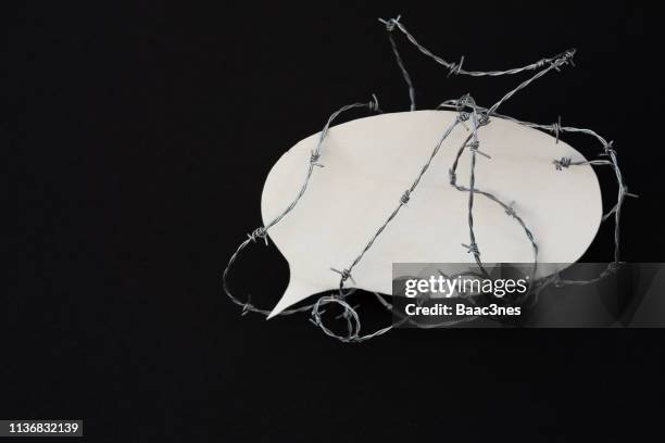 protect the freedom of speech - barbed wire around a speech bubble - media ban stockfoto's en -beelden