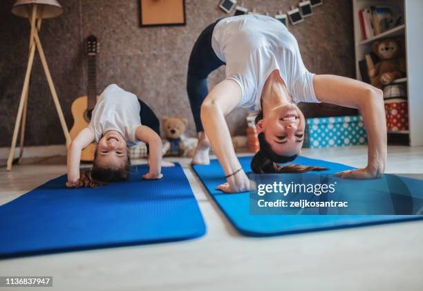 mother and daughter working out together doing exercise at home - kids exercising stock pictures, royalty-free photos & images