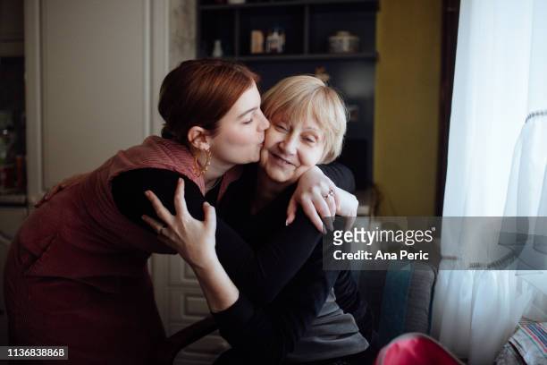 Young woman embracing and kissing her mother