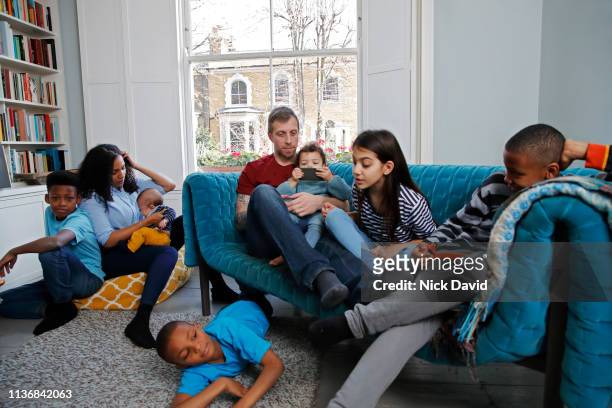 Family with six children relaxing in living room