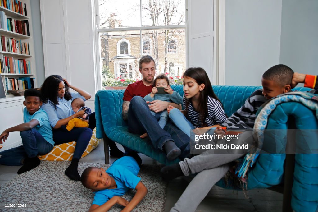 Family with six children relaxing in living room