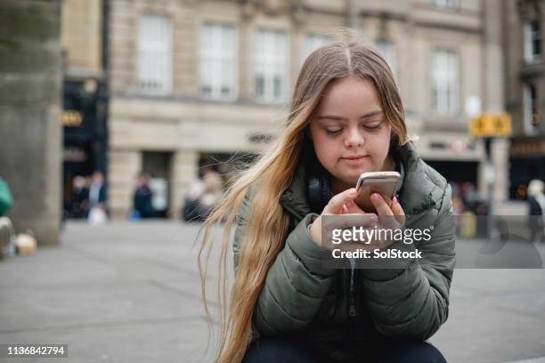 young adult using smart phone - disabilitycollection stock pictures, royalty-free photos & images