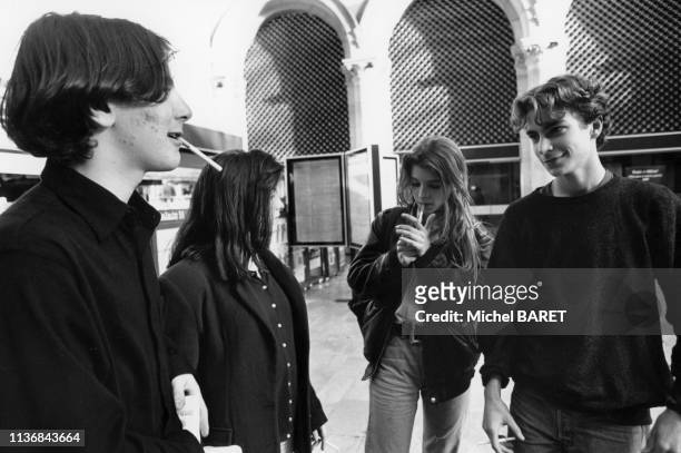 Groupe d'adolescents fumant des cigarettes dans le hall de la gare du Nord, à Paris, en janvier 1993, France.