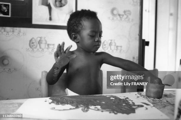 Enfant faisant de la peinture à la main dans la crèche Amédée-Laplace à Créteil, en 1994, dans le Val-de-Marne, France.