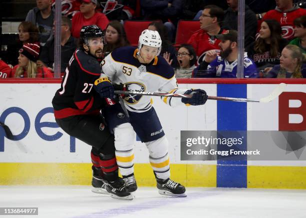 Justin Faulk of the Carolina Hurricanes battlles for position on the ice with Jeff Skinner of the Buffalo Sabres during an NHL game on March 16, 2019...