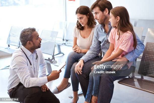 doctor discussing with girl's family at hospital - severe illness stock pictures, royalty-free photos & images