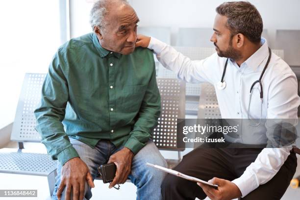 doctor consoling sad senior male patient - asian man sitting casual imagens e fotografias de stock