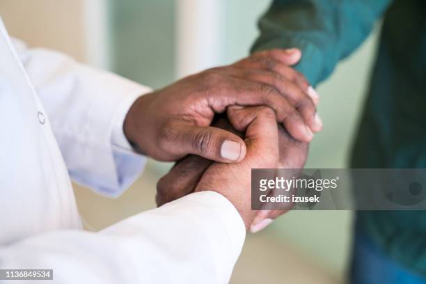 beskurna händer av läkare hälsning senior man - african american man helping elderly bildbanksfoton och bilder