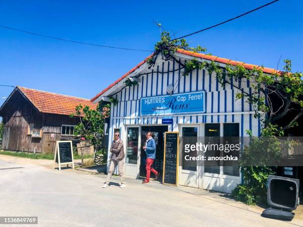 people visiting and tasting oysters in cap ferret, france - cap ferret stock pictures, royalty-free photos & images