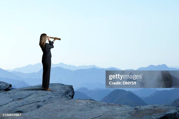 femme d'affaires avec le spyglass regardant dehors vers la gamme de montagne - see through photos et images de collection