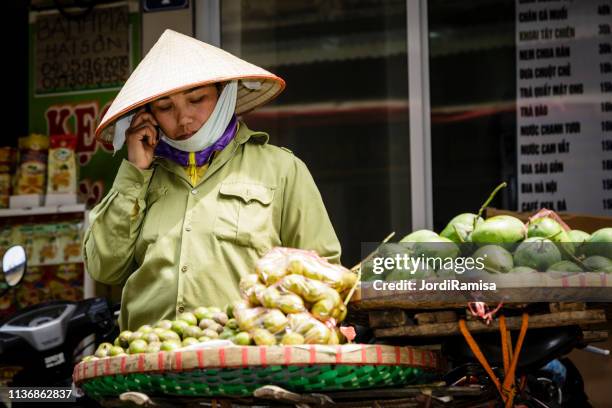 verkopers van de markt - asian style conical hat stockfoto's en -beelden