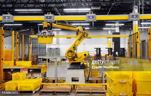 Robot picks up a tote containing product during the first public tour of the newest Amazon Robotics fulfillment center on April 12, 2019 in the Lake...