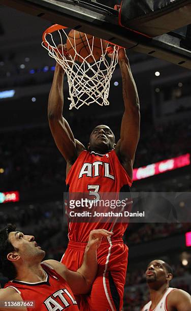 Damien Wilkins of the Atlanta Hawks dunks the ball over temmate Zaza Puchulia and Kurt Thomas of the Chicago Bulls in Game Two of the Eastern...