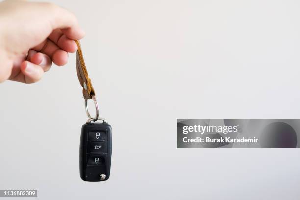 holding a car key against white background - car keys hand stockfoto's en -beelden