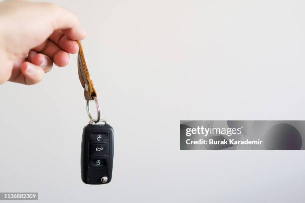 holding a car key against white background - car keys stock pictures, royalty-free photos & images