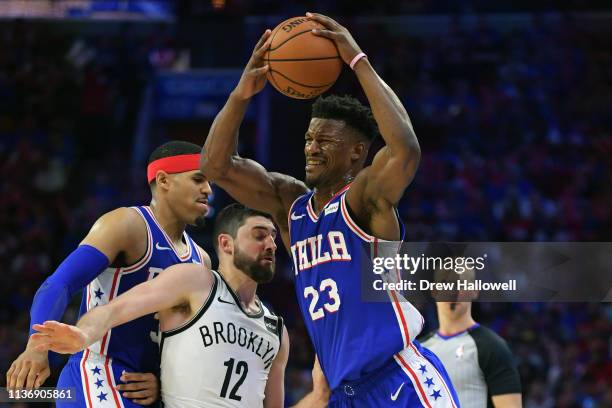 Jimmy Butler of the Philadelphia 76ers gets fouled by Joe Harris of the Brooklyn Nets as Tobias Harris defends in the second half during Game One of...