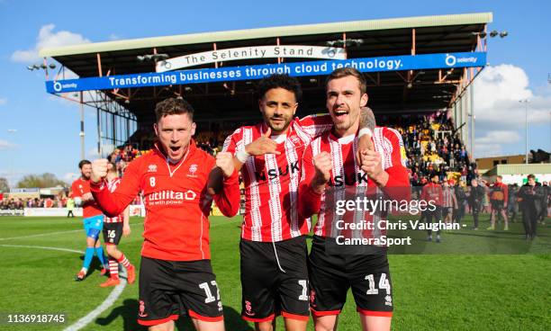 Lincoln City players, from left, Shay McCartan, Bruno Andrade, Harry Toffolo celebrate after securing promotion following the Sky Bet League Two...