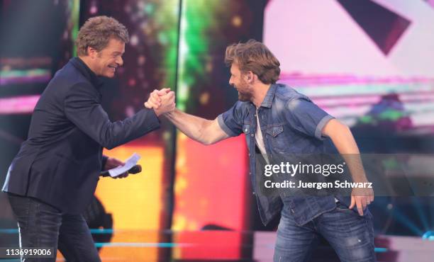 Oliver Geissen shakes hands with Nick Ferretti during the second event show of the tv competition "Deutschland sucht den Superstar" at Coloneum on...