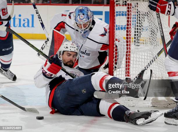 Matt Niskanen of the Washington Capitals stops a shot as Pheonix Copley defends in the second period against the New Jersey Devils at Prudential...