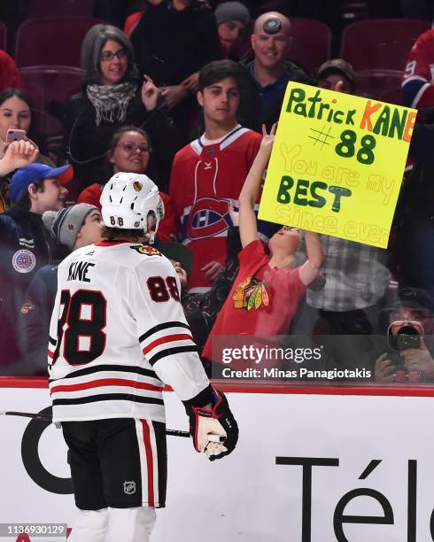 Patrick Kane of the Chicago Blackhawks tosses a puck to a young fan during the warm-up prior to the NHL game against the Montreal Canadiens at the...