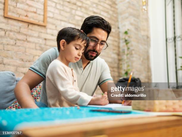 墨西哥父親和小兒子在家裡畫筆記本 - family drawing 個照片及圖片檔