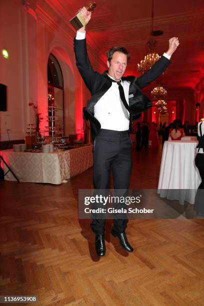 Philipp Hochmair poses with his award for most popular actor, jumps during the ROMY award at Hofburg Vienna on April 13, 2019 in Vienna, Austria.