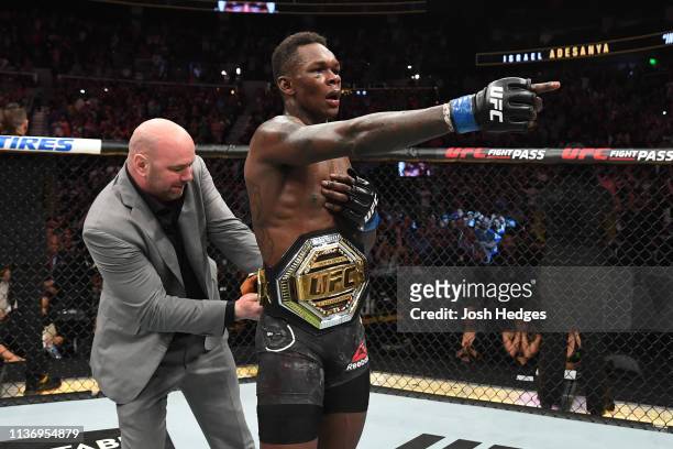 President Dana White places the interim middleweight championship belt on Israel Adesanya after defeating Kelvin Gastelum by unanimous decision in...