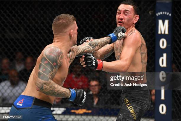 Dustin Poirier punches Max Holloway in their interim lightweight championship bout during the UFC 236 event at State Farm Arena on April 13, 2019 in...